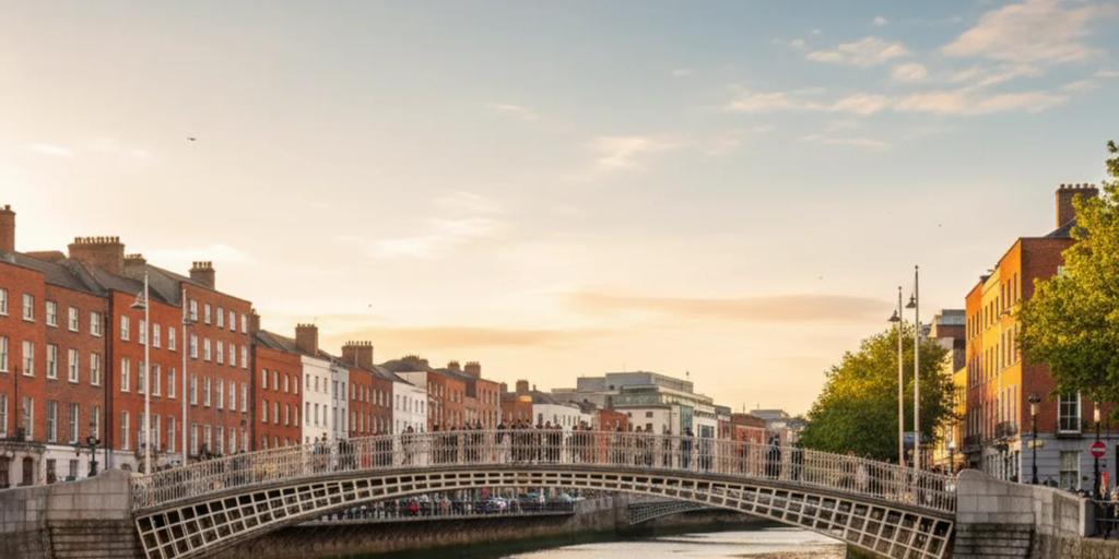 Most Ha'penny wygięty nad rzeką Liffey w Dublinie o zmierzchu