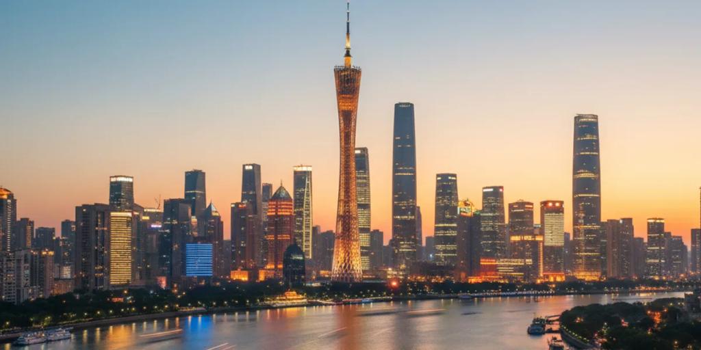 Canton Tower rozświetlona kolorami nad Rzeką Perłową nocą, z panoramą Zhujiang New Town w tle