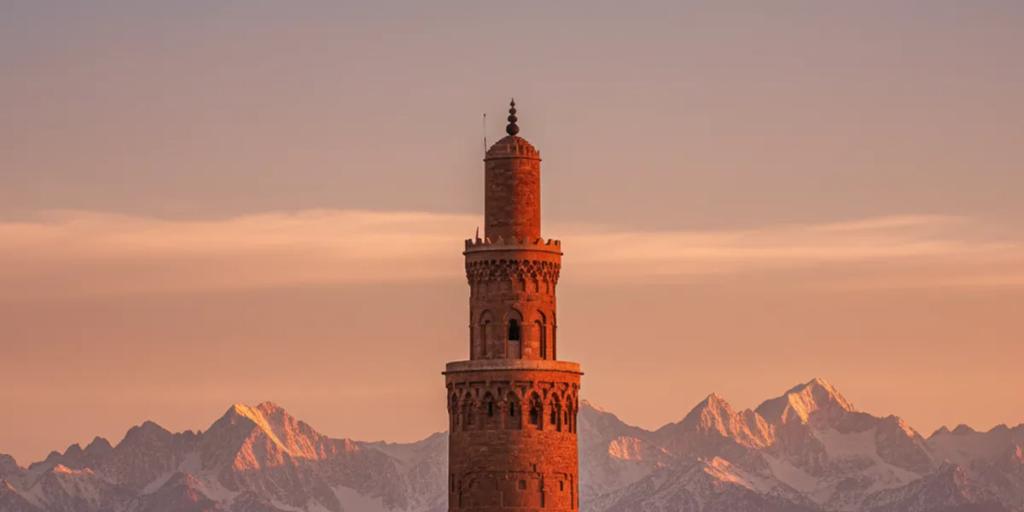Dachy medyny Marrakeszu z minaretem Kutubijja i przyprószonymi śniegiem górami Atlas w tle
